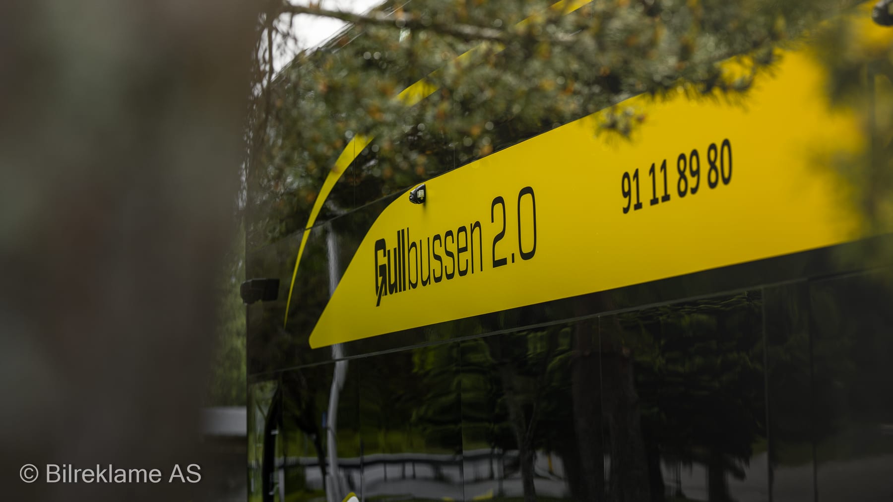 Navnet «Gullbussen 2.0» og telefonnummeret på siden av dobbeltdekkeren